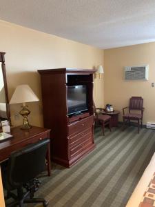 a living room with a tv and a chair at Albatross Hotel in Gander
