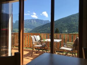 d'un balcon avec une table, des chaises et des montagnes. dans l'établissement Le Frenola, à Saint-Pierre-dʼEntremont