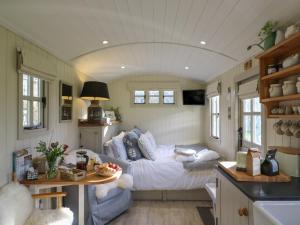 Gibson's Hut في Preston Candover: غرفة نوم مع سرير في منزل صغير