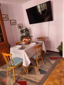 een eettafel met stoelen en een televisie aan de muur bij Piso centro Luanco in Luanco