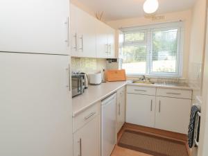 eine Küche mit weißen Schränken und einem Kühlschrank in der Unterkunft 304 Norton Park in Dartmouth + 15 Fotos