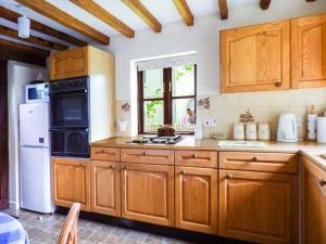 a kitchen with wooden cabinets and a white refrigerator at The Granary in Norwich