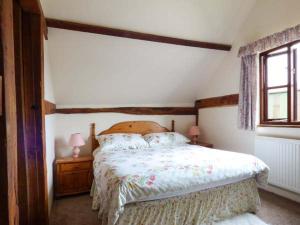 a bedroom with a bed and two lamps and a window at The Granary in Norwich