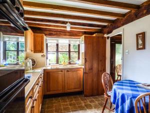 a kitchen with wooden cabinets and a table with a blue table cloth at The Granary in Norwich