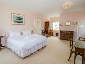 a bedroom with a large white bed and a desk at The White House in Grange Over Sands