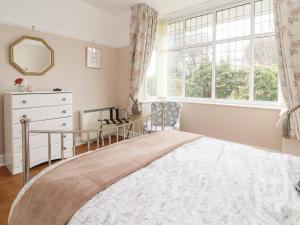 a bedroom with a large bed and a window at Coniston in Colwyn Bay