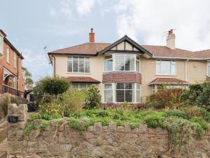 a house with a stone wall in front of it at Coniston in Colwyn Bay