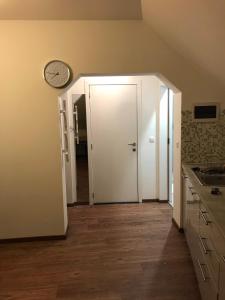 a kitchen with a door and a clock on the wall at Apartement Zaventem in Zaventem