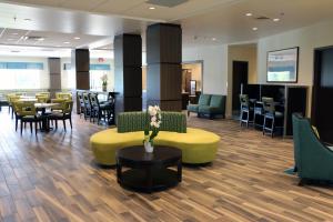 a lobby with a waiting room with tables and chairs at Holiday Inn Express & Suites - Hendersonville SE - Flat Rock by IHG in Flat Rock
