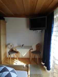 a living room with a table and two chairs and a tv at Appartement Raggl in Jerzens