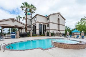 a swimming pool in front of a building with a house at Holiday Inn Express Hotel and Suites Lake Charles, an IHG Hotel in Lake Charles