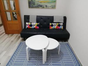 sala de estar con sofá negro y mesa blanca en Monsalve10, en Zamora