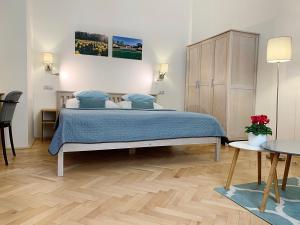 sypialnia z łóżkiem z niebieską pościelą i drewnianą podłogą w obiekcie Marienbad Apartment w Mariańskich Łaźniach