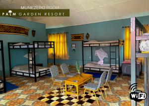 Zimmer mit Etagenbetten sowie einem Tisch und Stühlen in der Unterkunft Palm garden Resort in Gisenyi
