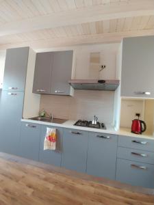 a kitchen with white cabinets and a sink at Appartamento Masha Como in Mozzate