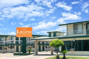 an exterior view of a inn and suites sign at Executive Inn & Kitchenette Suites-Eagle Pass in Eagle Pass