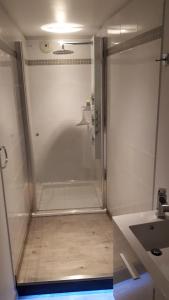 a shower with a glass door in a bathroom at L étoile du verger in Barcelonnette