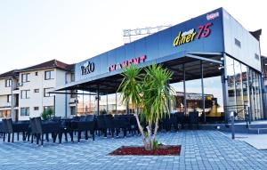 a restaurant with a palm tree in front of a building at Hotel Moment in Velika Plana