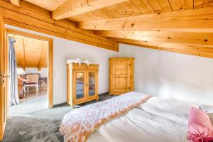 una camera con letto e soffitto in legno di The Alpine Apartment a Garmisch-Partenkirchen