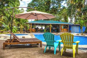 波多維耶荷的住宿－賽里那布拖維約旅館，游泳池旁的两把椅子、一张桌子和一把遮阳伞