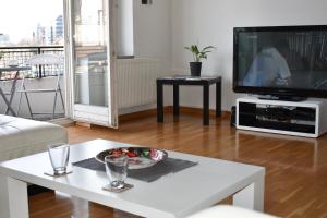 ein Wohnzimmer mit einem TV und einer Schale mit Obst auf dem Tisch in der Unterkunft Apartment Tino in Zagreb