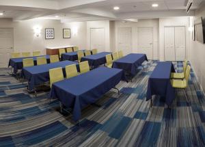 een conferentiezaal met blauwe tafels en gele stoelen bij Holiday Inn Express Hotel & Suites White River Junction, an IHG Hotel in White River Junction