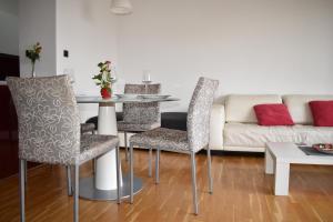 een woonkamer met een tafel en stoelen en een bank bij Apartment Tino in Zagreb