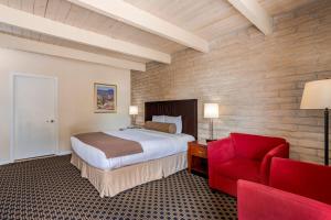 
a hotel room with a bed and a chair at Kayenta Monument Valley Inn in Kayenta

