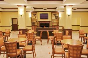 a large room with tables and chairs and a tv at Holiday Inn Express Hotel & Suites Winnie, an IHG Hotel in Winnie
