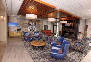 a living room with blue chairs and a table at Holiday Inn & Suites Sioux Falls - Airport, an IHG Hotel in Sioux Falls