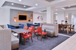 um restaurante com mesas e cadeiras e uma sala de espera em Holiday Inn Express Hotel & Suites San Antonio NW-Medical Area, an IHG Hotel em San Antonio