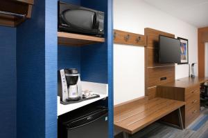 a room with a kitchen with a tv and a coffee maker at Holiday Inn Express & Suites San Antonio North-Windcrest, an IHG Hotel in San Antonio