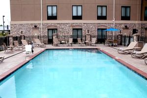 a large swimming pool with chairs and a building at Holiday Inn Express & Suites Paducah West, an IHG Hotel in Paducah