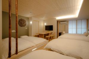 a bedroom with two beds and a table with a television at so, KANAZAWA in Kanazawa