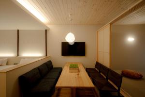 金沢市にあるso, KANAZAWAのソファ、テーブル、テレビが備わる客室です。