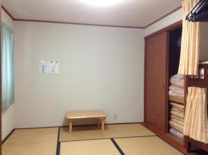una habitación con un banco en la esquina de una habitación en Lodge Skade, en Omachi