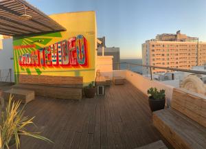 モンテビデオにあるCircus Hostel&Hotel Montevideoの建物の側面にカラフルな看板が付いたバルコニー