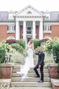 a bride and groom on the steps of a mansion at Mercersburg Inn in Mercersburg