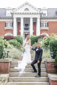 a bride and groom posing on the steps of a mansion at Mercersburg Inn in Mercersburg