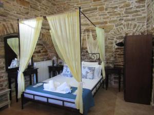 a bedroom with a bed with a canopy at Vouno Village Apartments in Vounós