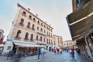 un grupo de personas caminando por una calle de la ciudad en Classy Venice, en Venecia 11 fotos más