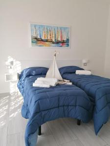a room with three blue beds with sailboats on the wall at B&B Audafra in Crotone
