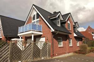 a red brick house with a black roof at Jordsand in Horumersiel