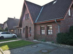 a brick house with a car parked in front of it at Dünenrose in Horumersiel