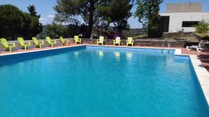 uma grande piscina com cadeiras amarelas e água azul em Quinta Das Lameirinhas em Marvão