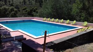 uma grande piscina com cadeiras num pátio em Quinta Das Lameirinhas em Marvão