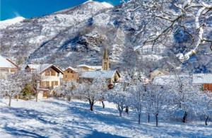 un pueblo en la nieve con una montaña en el fondo en STUDIO CENTRE AURON, en Auron