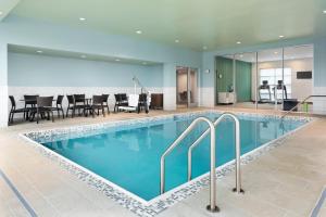 einen Pool in einem Hotelzimmer mit Stühlen und Tischen in der Unterkunft Holiday Inn Express & Suites Duluth North - Miller Hill, an IHG Hotel in Hermantown