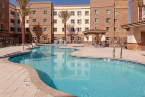 une grande piscine dans la cour d'un bâtiment dans l'établissement Holiday Inn Express & Suites - Gilbert - East Mesa, an IHG Hotel, à Gilbert