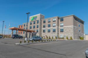 ein großes Gebäude mit Autos auf einem Parkplatz in der Unterkunft Holiday Inn Express & Suites Clarion, an IHG Hotel in Clarion